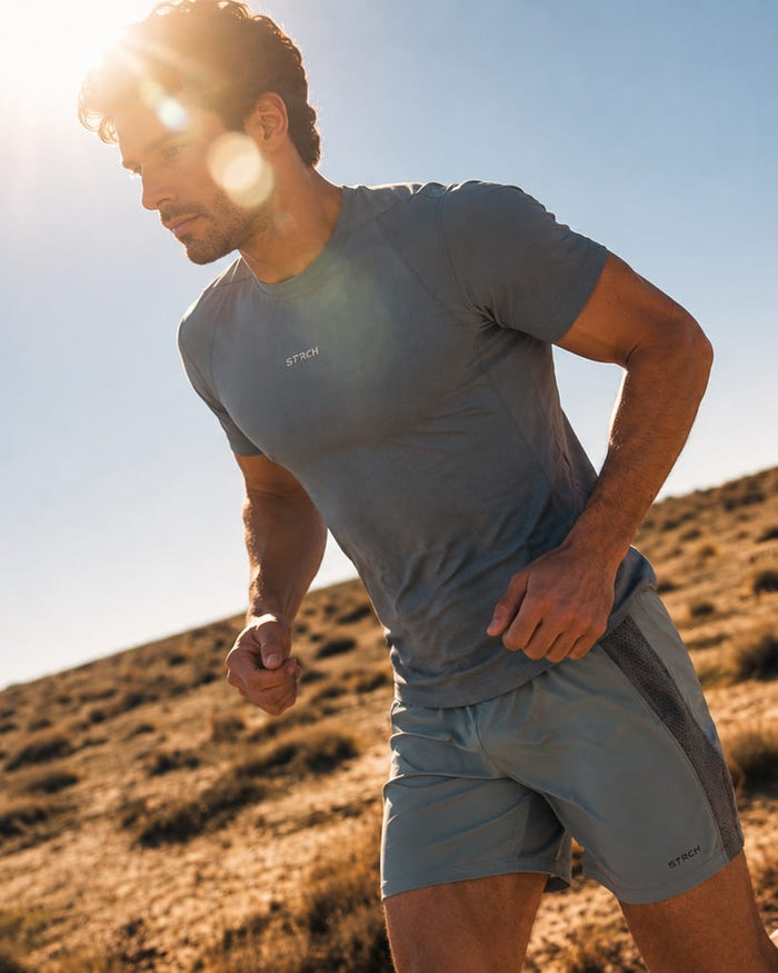 Runner in a STRCH tee on a sunny hillside